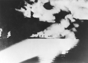 Figure 5: A victim of insufficient pre-war preparation, USS Quincy (CA-39), photographed from a Japanese cruiser during the Battle of Savo Island, off Guadalcanal, 9 August 1942. Quincy, seen here burning and illuminated by Japanese searchlights, was sunk in this action. (Naval History and Heritage Command, NH 50346)