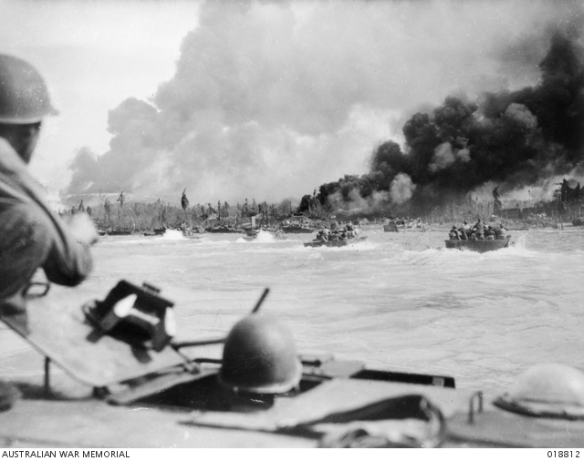 Last dash to shore, aboard American manned Alligators, during the landing of Australian troops at Balikpapan, Borneo. Smoke from the ruins of enemy positions and burning oil wells is visible in the background. Shore installations were subjected to an intensive naval bombardment before the landing operation. (Australian War Memorial ID #018812)